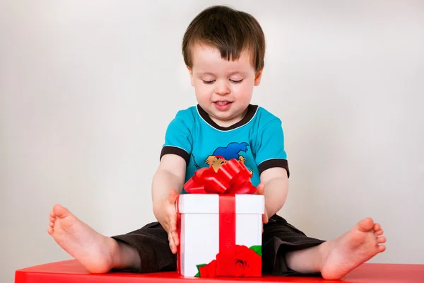 Happy toddler boy opening gift box — Stock Photo, Image