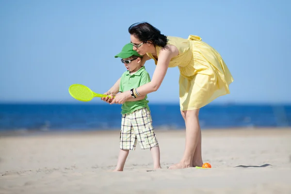 Young mother teaching her son to play tennis — Stock Photo, Image