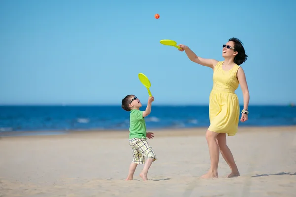 Jovem mãe e filho brincando na praia — Fotografia de Stock
