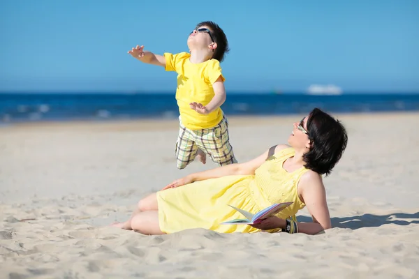 Jovem mãe e filho se divertindo na praia — Fotografia de Stock