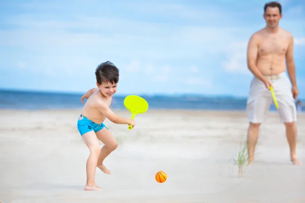 Vater und Sohn spielen Tennis am Strand — Stockfoto