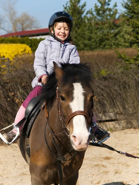 Preschool girl ride on pony — Stock Photo, Image