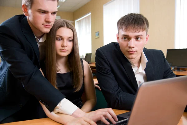 Guapos hombres de negocios jóvenes que trabajan en el ordenador portátil en la oficina — Foto de Stock