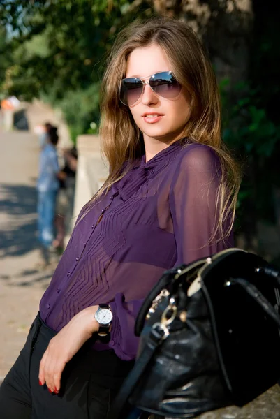 Beautiful girl with a handbag and dark glasses — Stockfoto