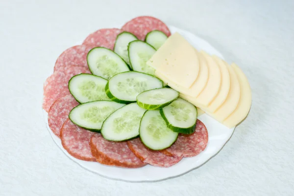 stock image Cut cheese, sausage and cucumber in a plate