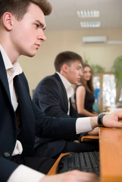 Jungunternehmer sitzt am Tisch und bedient sich des Computers — Stockfoto