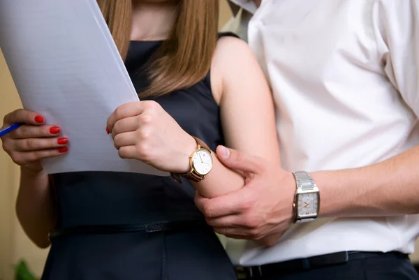 Frau hält Dokument und Mann in der Nähe hält ihre Hand — Stockfoto
