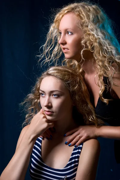 Duas meninas bonitas contra um fundo escuro — Fotografia de Stock