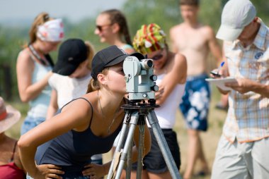 Student works with a theodolite clipart