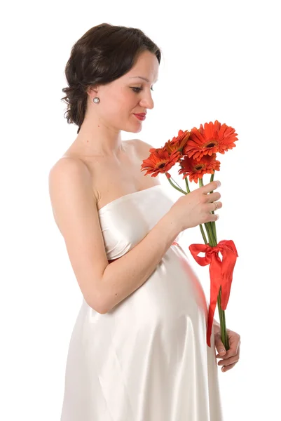 Pregnant woman looks at a bunch of flowers — Stock Photo, Image