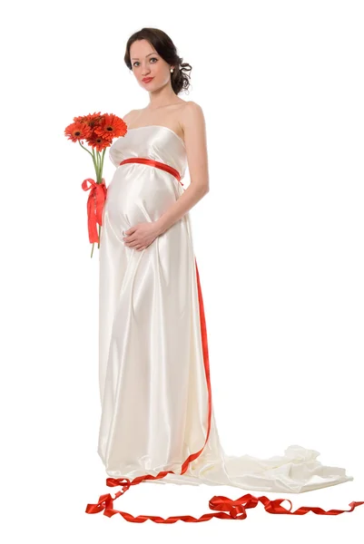 Pregnant woman in a white dress with a bunch of flowers — Stock Photo, Image