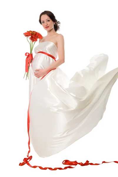 Pregnant woman in a white dress with a bunch of flowers — Stock Photo, Image