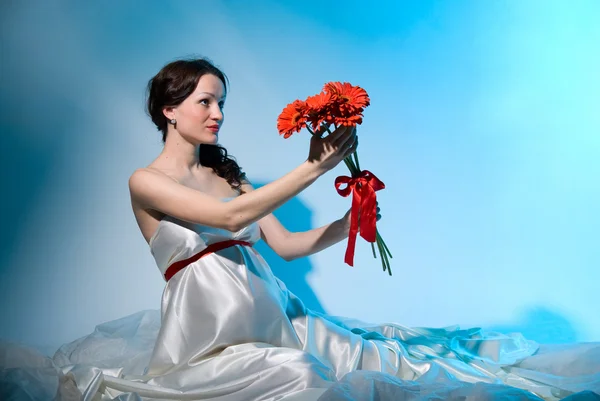 Mujer embarazada sostiene flores en los brazos extendidos —  Fotos de Stock