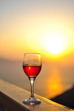 Bir bardak kırmızı şarapla güzel bir deniz batımı.