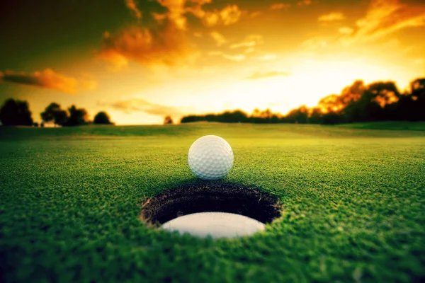 Bola de golfe perto de buraco — Fotografia de Stock
