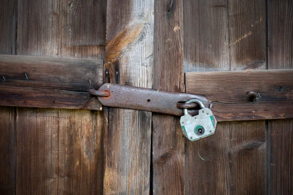 Stare drewniane drzwi z zielonym kłódka — Zdjęcie stockowe