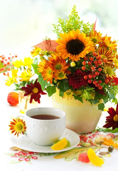 Cup of tea and autumnal flowers — Stock Photo, Image