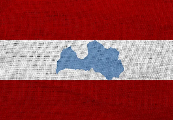 Vlajka a mapa Lotyšska na pytlovině — Stock fotografie