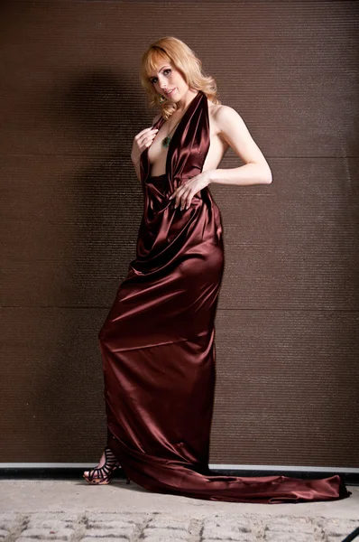 Menina loira bastante confiante em vestido de noite, posando contra um — Fotografia de Stock