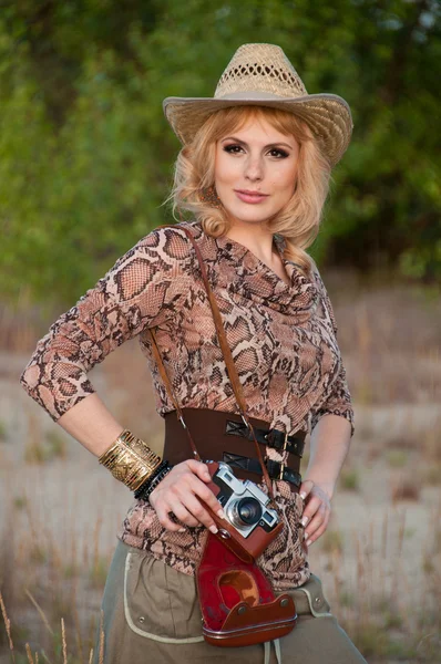 Aranyos szőke lány, egy cowboy kalapot, és a kamera a kezében — Stock Fotó