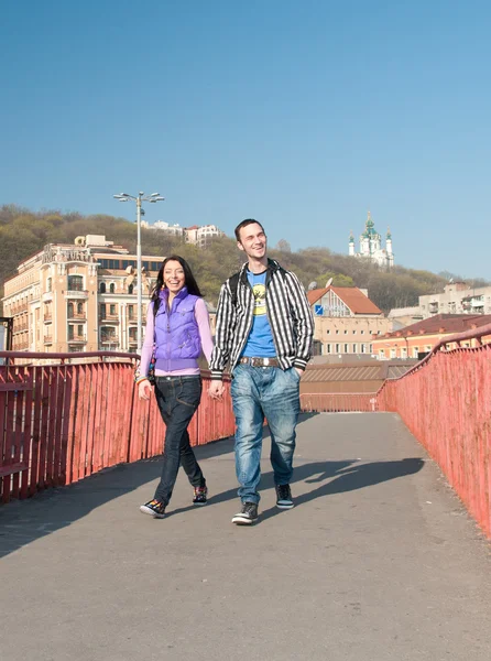 Um casal feliz. Garoto e menina sorrindo e andando na cidade — Fotografia de Stock