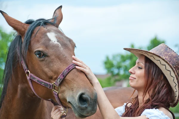 美丽的黑发女孩抚摸一匹马 — 图库照片