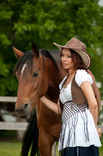 Ein schönes Mädchen mit Cowboyhut und Pferd — Stockfoto