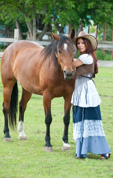 Красивая девушка в ковбойской шляпе с лошадью — стоковое фото