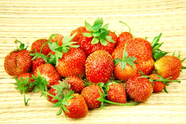 Tuin aardbeien op een stro achtergrond — Stockfoto
