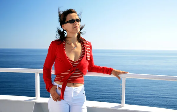 Jonge vrouw in cruise op voering zeegezicht achtergrond — Stockfoto