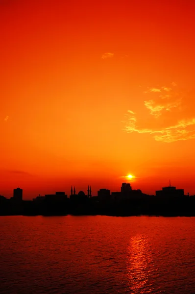Silhouette de skyline urbaine isolée sur le coucher de soleil orange et r — Photo