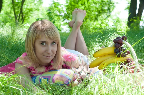 Das junge Mädchen liegt auf einem grünen Gras — Stockfoto