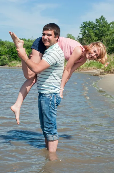 Junges Mädchen und der Kerl am Flussufer — Stockfoto
