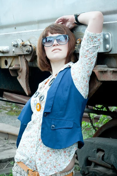 Das schöne Mädchen in der Nähe eines rostigen Eisenbahnwaggons — Stockfoto