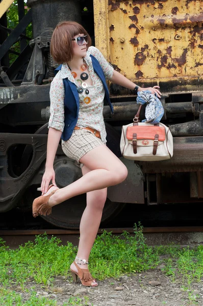 Das schöne Mädchen in der Nähe eines rostigen Eisenbahnwaggons — Stockfoto