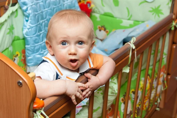 Baby steht im Kinderbett — Stockfoto