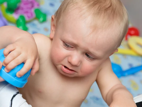 Baby cries holding a toy — Stock Photo, Image