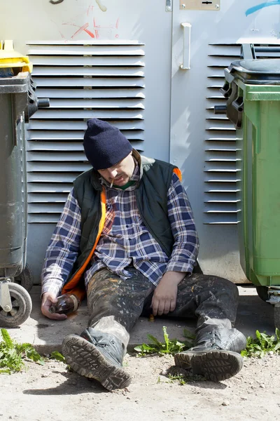 Vagabundo durmiendo cerca de basureros — Foto de Stock