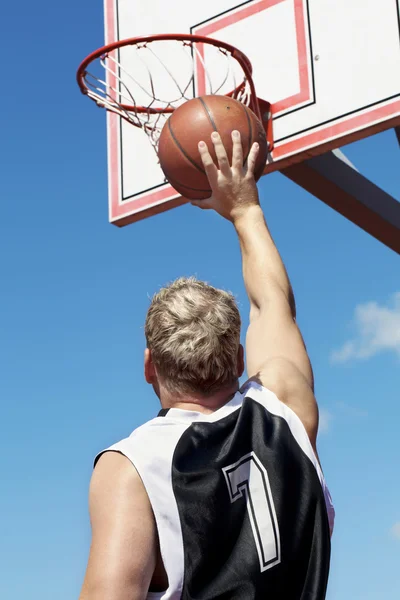 Basketbalový hráč hází míč do koše — Stock fotografie