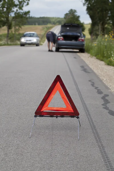 Trójkąt ostrzegawczy na drogę przed samochodem — Zdjęcie stockowe