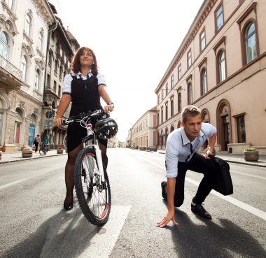 Bisiklet süren ve şehirde koşan iş adamları