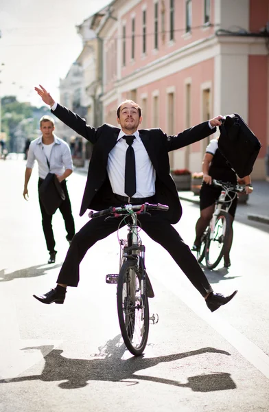 Empresarios andando en bicicleta y corriendo en la ciudad — Foto de Stock