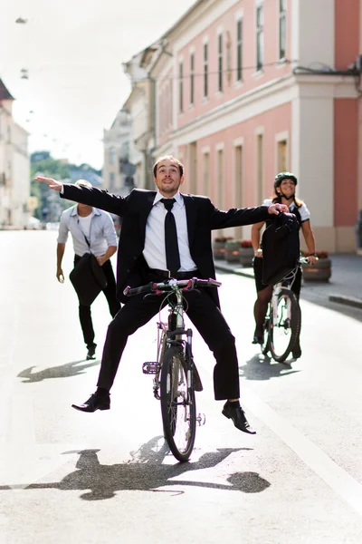 Empresários andando de bicicleta e correndo na cidade — Fotografia de Stock