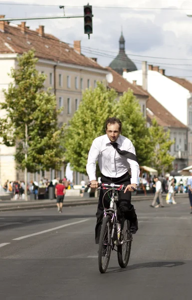 Jovem empresário montando uma bicicleta na cidade — Fotografia de Stock