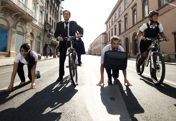 Podnikatelé jezdící na kolech a běh ve městě — Stock fotografie
