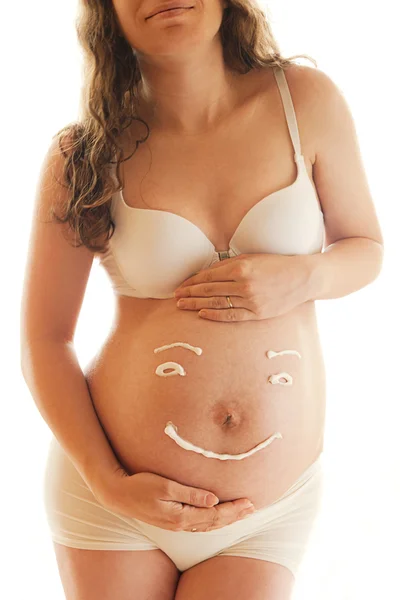 妊娠中の女性腹クリーム笑顔で — ストック写真