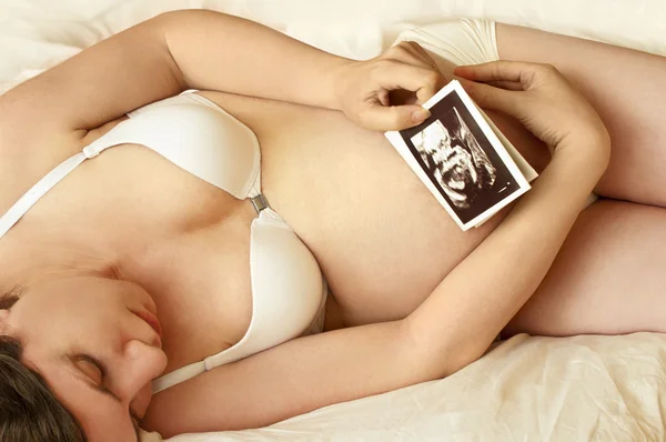 Pregnant woman looking at ultrasound scan — Stock Photo, Image