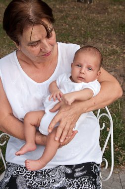 Senior Woman Holding His Great-grandson clipart