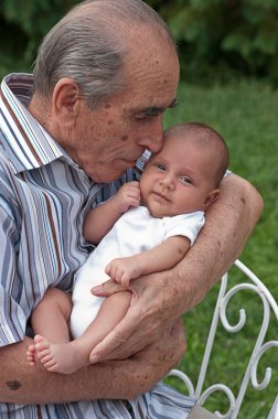 Senior Man Holding His Great-grandson clipart