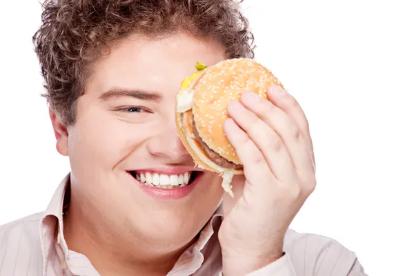 Jeune homme potelé tenant hamburger — Photo